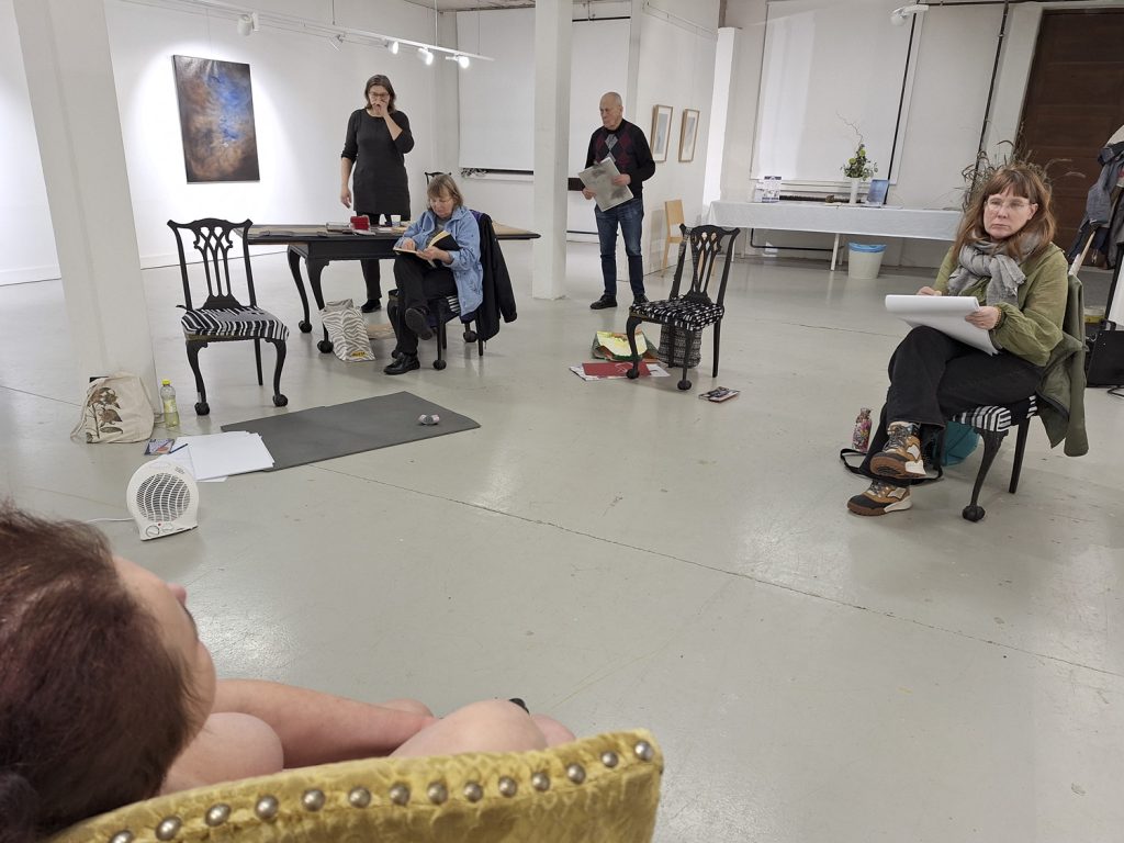 Illan piirtäjät etsivät paikkaansa Galleria Joutsenen Elävän mallin piirustusillassa. Malli, Mirva (edessä vasemmalla), on jo paikoillaan. Rivistössä vasemmalla vetäjä Anna-Maija Junnila.
