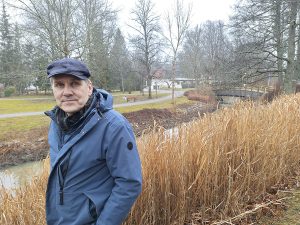 Kaupunginpuutarhuri Matti Nikander poseeraa Vähäjoen rannassa. Joenpenkassa kasvava mammuttiheinä voi hyvin.