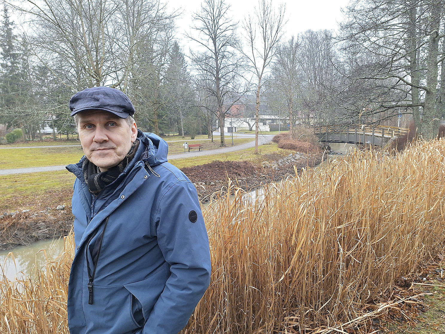 Kaupunginpuutarhuri Matti Nikander poseeraa Vähäjoen rannassa. Joenpenkassa kasvava mammuttiheinä voi hyvin.