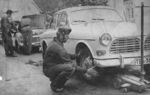 Auton katsastusta Anjalantiellä vuonna 1969. ”Vanhoina hyvinä aikoina” autot saattoivat oikutella varsin erilaisista syistä kuin nykyään, ja mitä enemmän moottoriajoneuvoja alkoi katukuvassa näkyä, sitä suurempi tarve oli myös ammattikorjaajille.